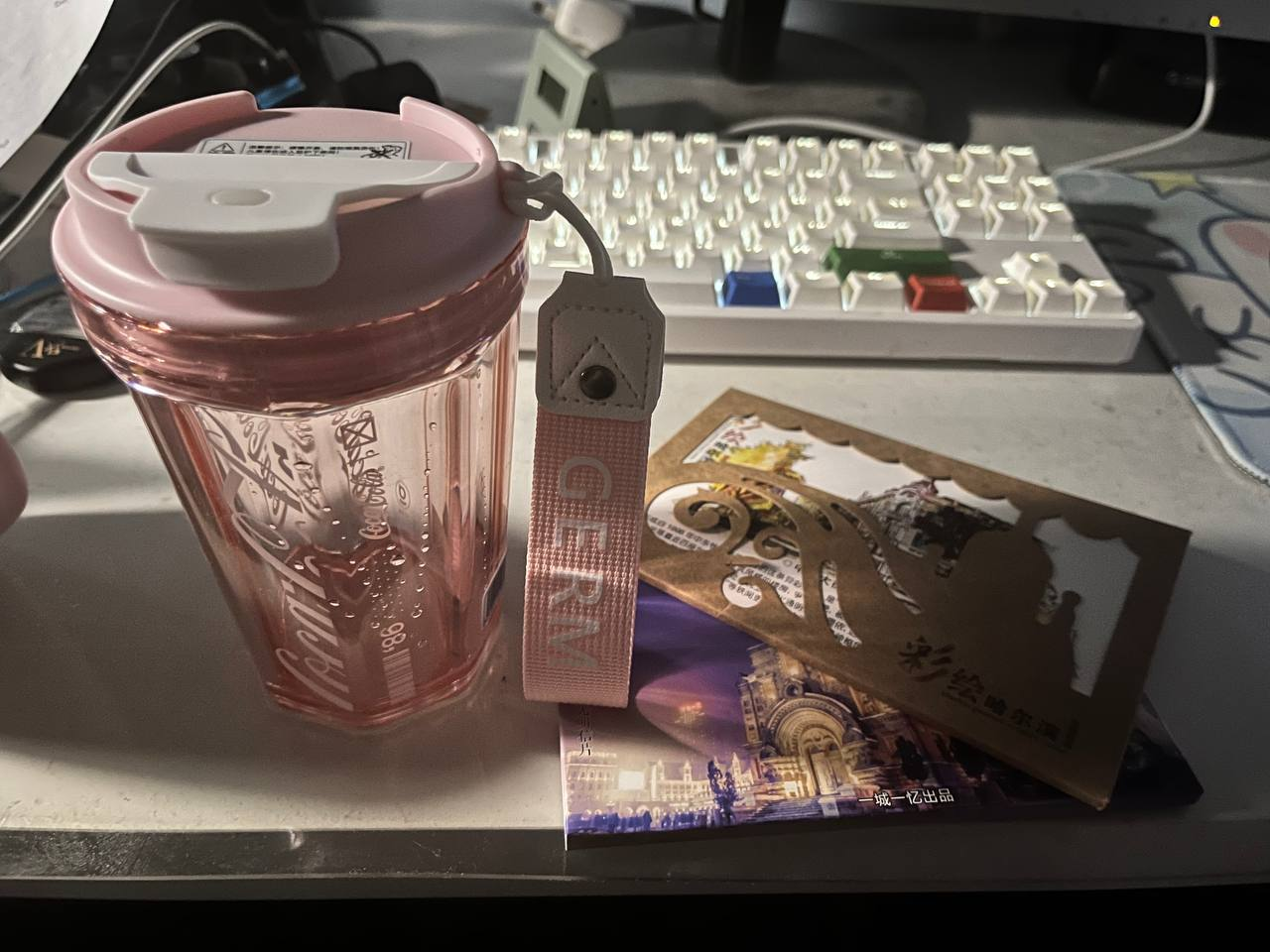 左邊是在可口可樂店里一見鍾情的粉色的可口可樂杯子，右邊是兩套哈爾濱的明信片